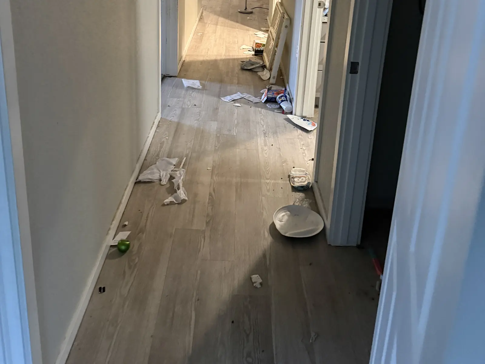 Household debris along an interior hallway before a property cleanout